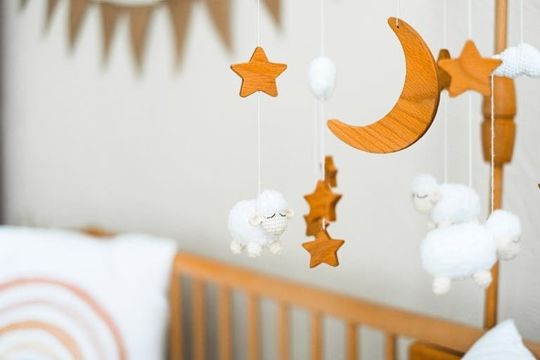 Houten DIY mobiel boven babybed in babykamer